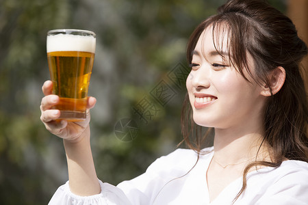 拿着啤酒微笑的年轻女子图片