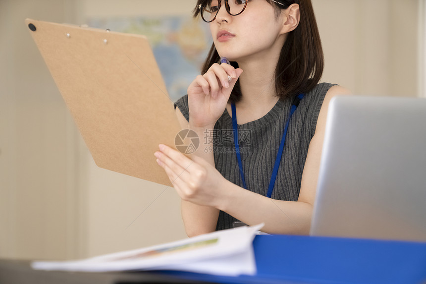 看着文件的职业女性图片