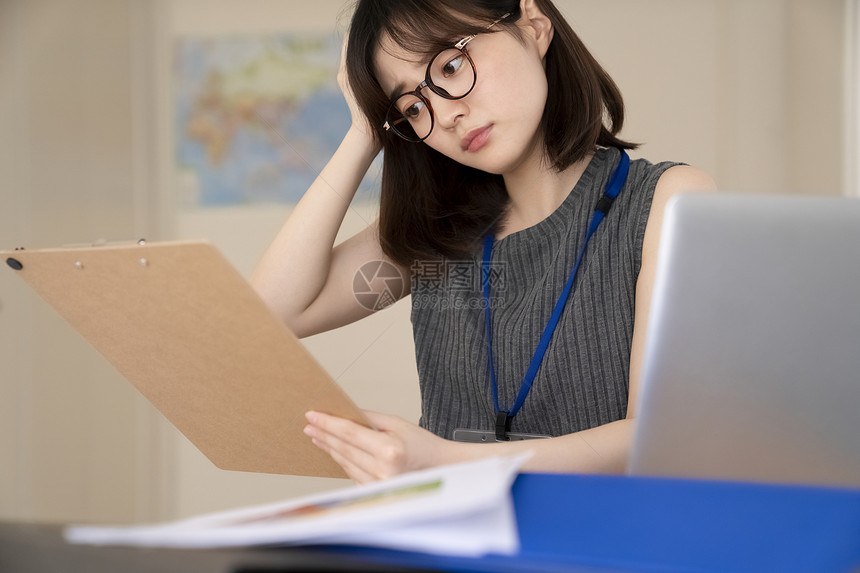 看着文件思考的青年女子图片