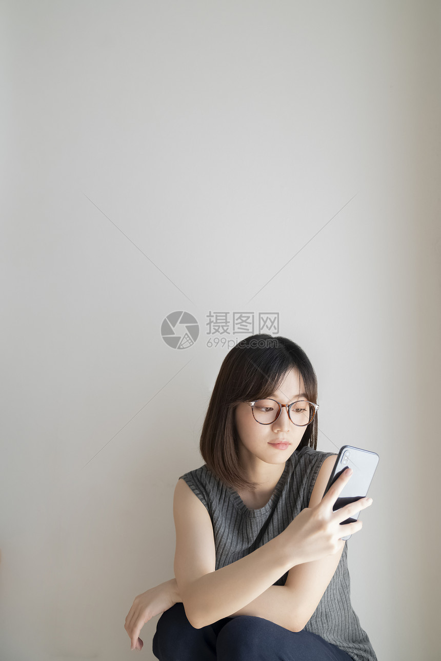 独自玩手机的年轻女子图片