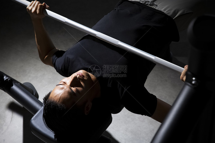 健身房锻炼举杠铃的成年男子图片