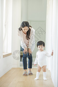 走廊陪着孩子练习走路的母亲图片