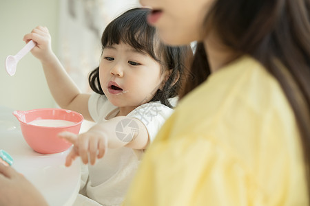 拿着勺子喝酸奶的小女孩图片
