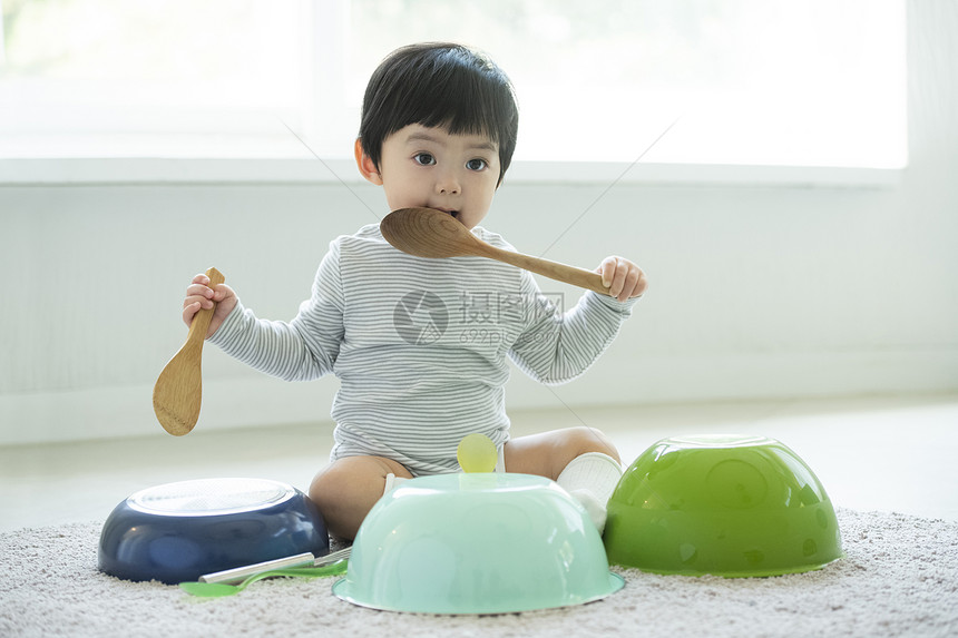 拿着厨具独自玩耍的小男孩图片