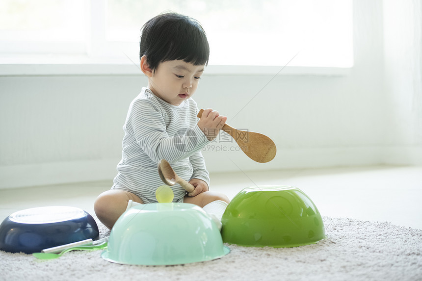 小朋友在客厅地毯上边吃饭边玩耍图片