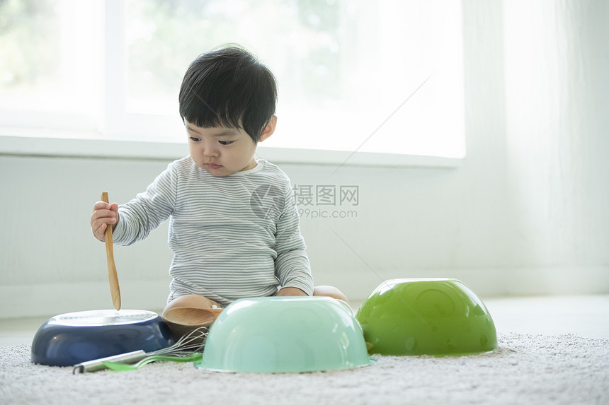 小朋友在客厅地毯上边吃饭边玩耍图片