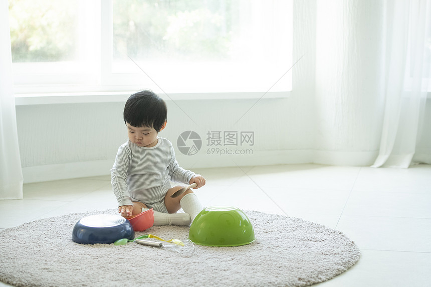 小朋友在客厅地毯上边吃饭边玩耍图片