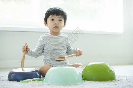 小朋友在客厅地毯上边吃饭边玩耍图片