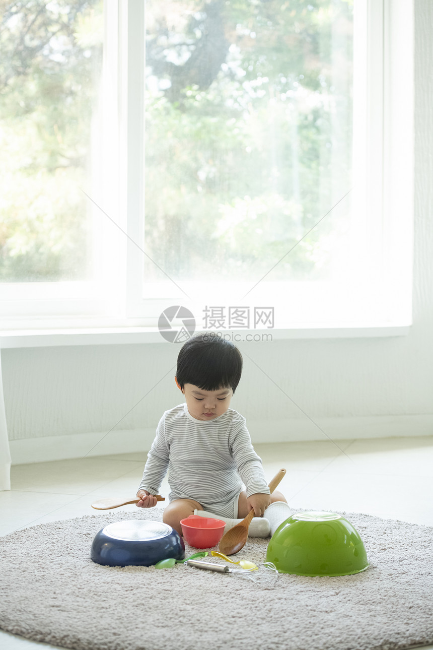 小朋友在客厅地毯上边吃饭边玩耍图片