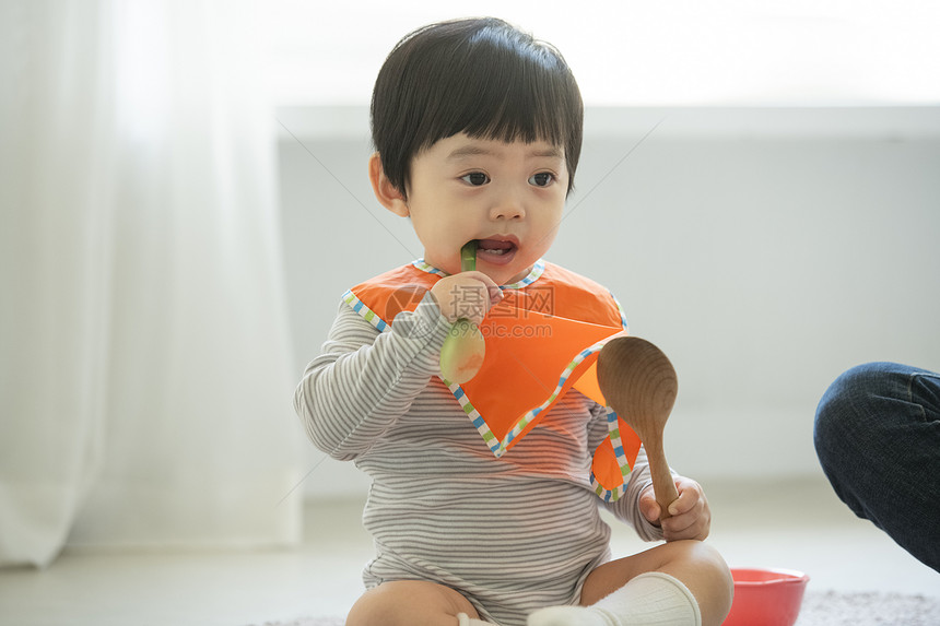 妈妈陪小朋友在客厅地毯上吃饭图片