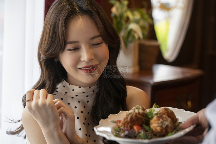 餐厅看着食物微笑的成年女子图片