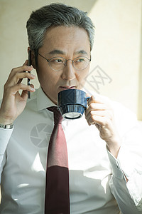 接听电话喝咖啡的商人图片