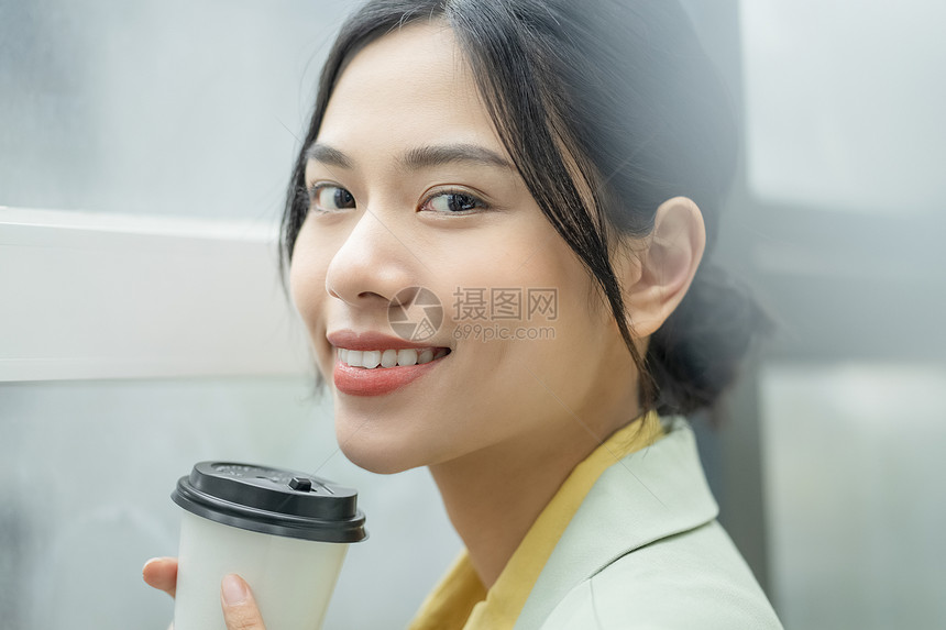 拿着咖啡微笑的职业女性图片