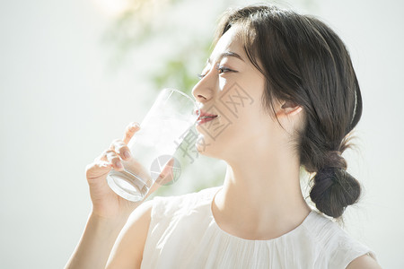 拿着水杯喝水的青年女子图片