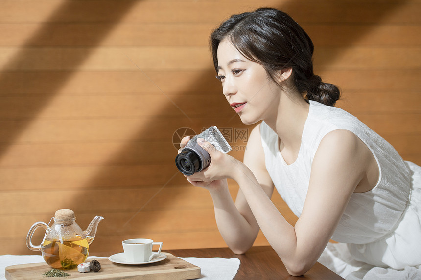 茶馆拿着相机的青年女子图片