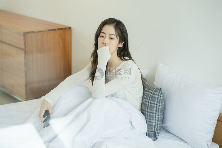 坐在床上发呆的青年女子图片