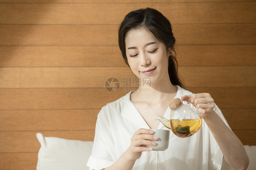 倒茶微笑的青年女子图片