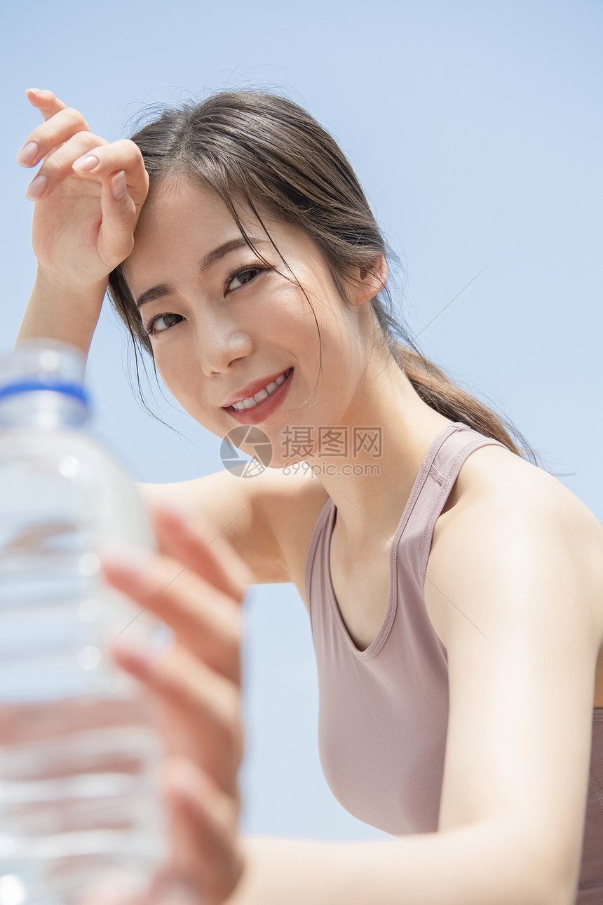 户外运动拿着水的女青年图片