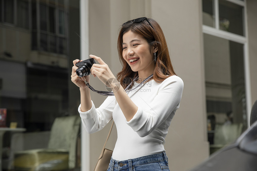 拿着相机微笑的青年女子图片