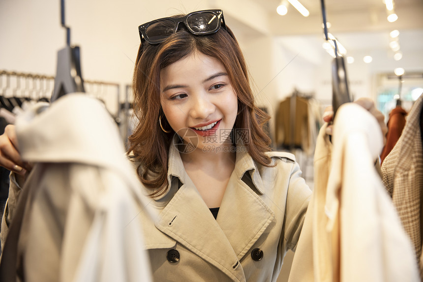 青年女子购物挑选衣服图片