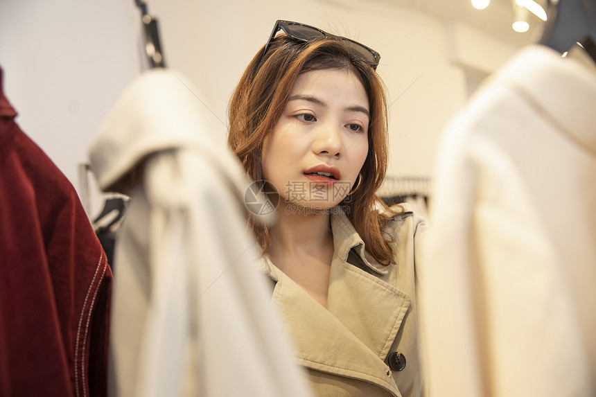 挑选衣服购物的年轻女子图片