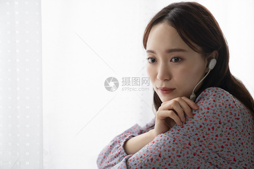 年轻女子戴着耳机听音乐图片