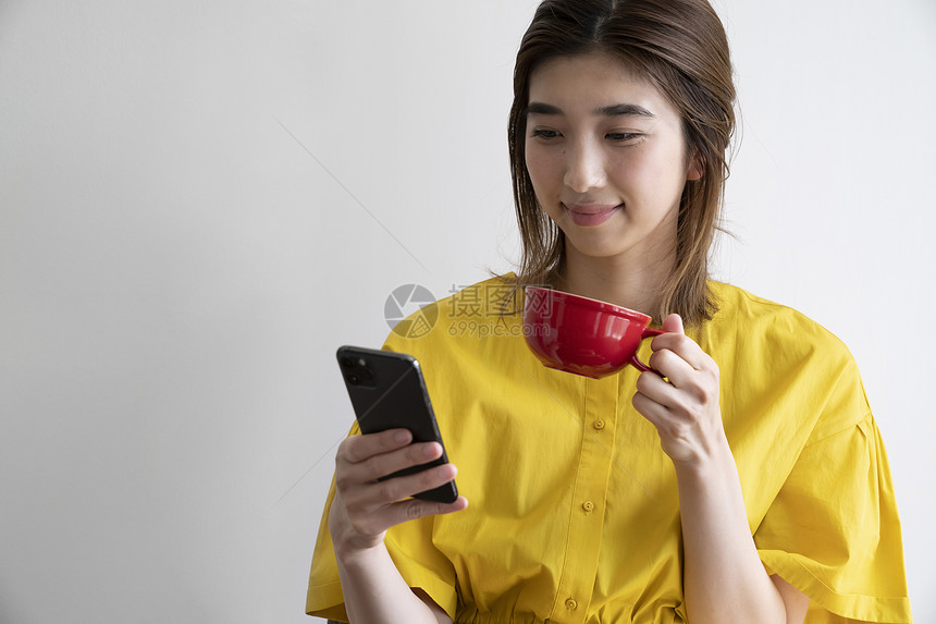 喝咖啡看着手机的青年女子图片