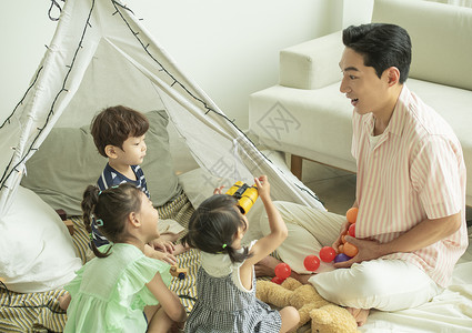 居家客厅陪伴孩子们玩耍的父亲背景图片
