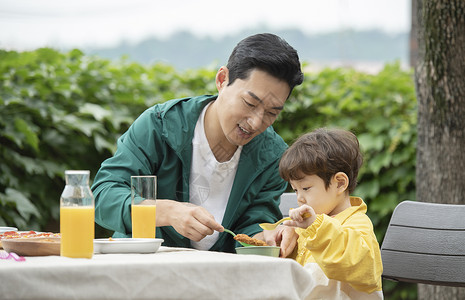 户外野餐喂孩子吃东西的父亲图片