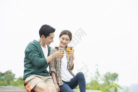 周末郊游喝啤酒的年轻夫妇图片