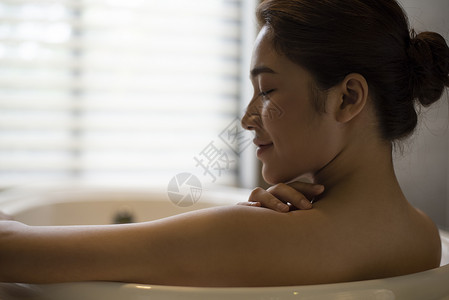 浴缸里泡澡沐浴的年轻女子背景图片