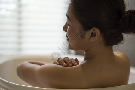 浴缸里泡澡享受的年轻女子背景图片