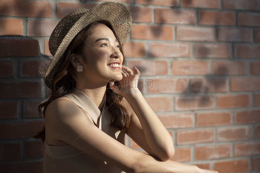 戴着遮阳草帽开心的度假美女图片