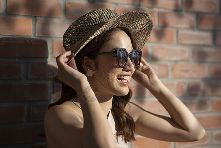 夏日戴着草帽和墨镜的年轻女子图片