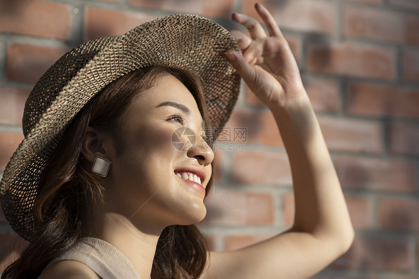 户外戴着草帽开心的年轻女子图片