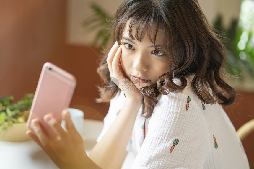 年轻女子拿着手机自拍图片