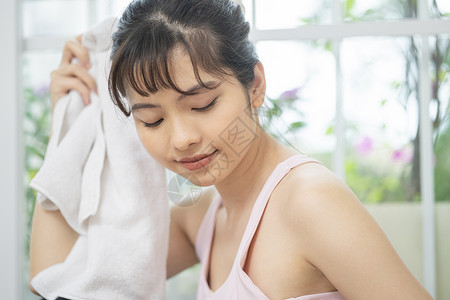 年轻女子拿着毛巾擦汗图片