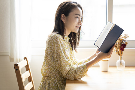 居家窗边阅读的年轻女子图片