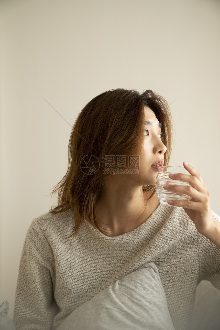 一个女人在房间里喝饮料图片