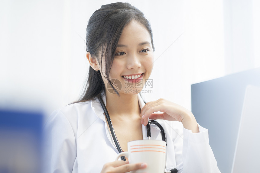 拿着水杯微笑的青年女医生图片