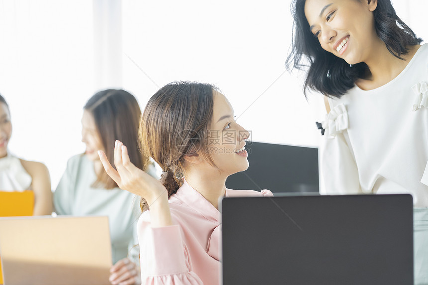 办公室讨论工作的商务女性图片
