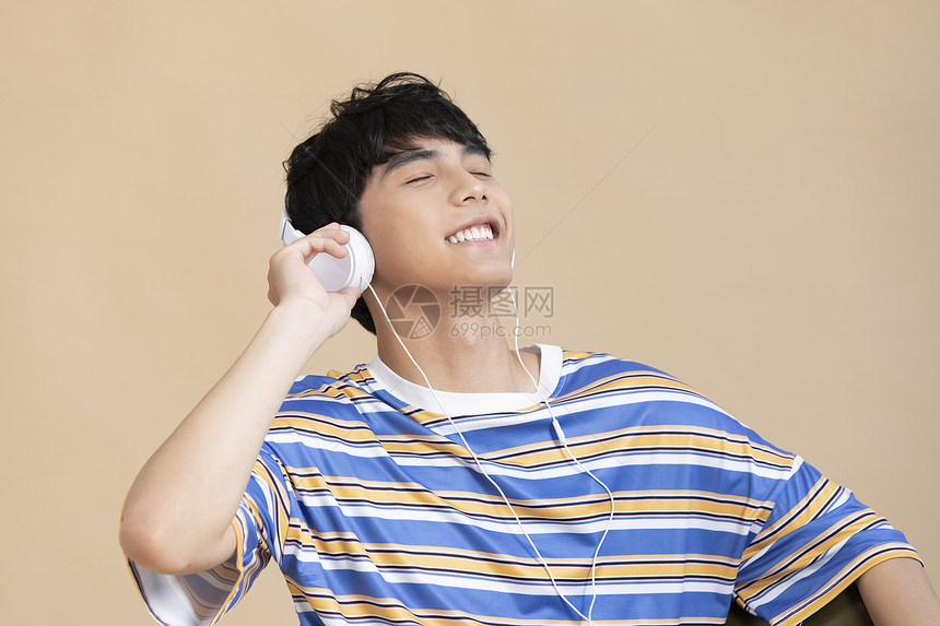 戴上耳机听音乐的男大学生图片