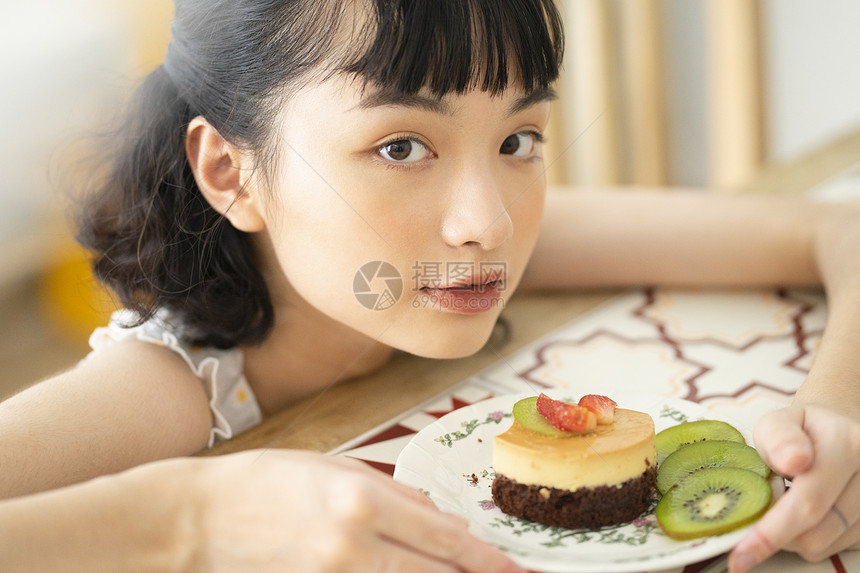 下午茶吃蛋糕的年轻女子图片