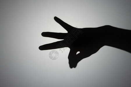 手部掐捏手势影子背景图片