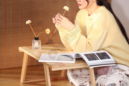 香薰美女居家女性坐在桌子前手上拿着花背景
