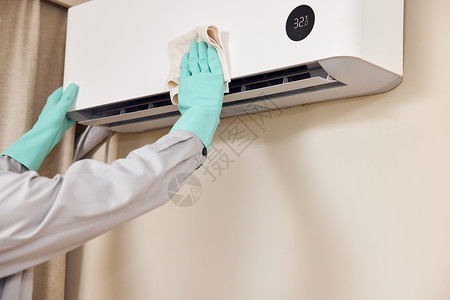 维修工人使用抹布清洁空调机特写高清图片