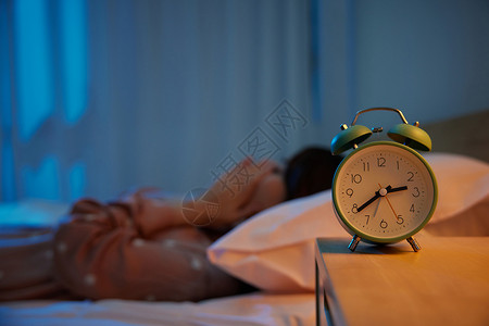 橙光现代素材夜晚躺在床上哭泣的女性和闹钟特写背景