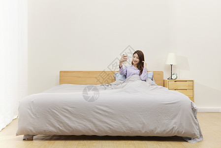 居家床上自拍的女生背景图片