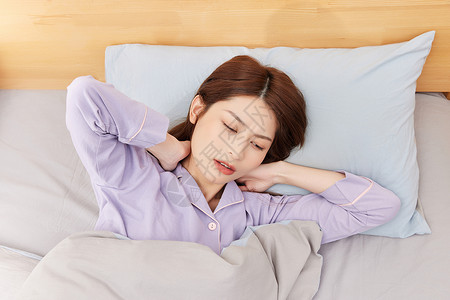 睡眠问题躺在床上颈椎感到不适的年轻女性背景