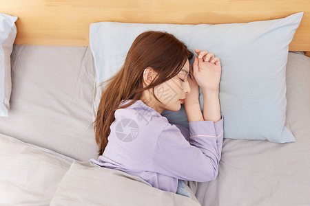 躺在床上睡觉的年轻女性高清图片